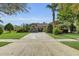 Inviting single-story home with a brick driveway, lush landscaping, and a warm, welcoming facade at 6240 Tremayne Dr, Mount Dora, FL 32757