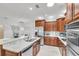 Well-equipped kitchen featuring stainless steel appliances, stone backsplash, and wood cabinetry at 6240 Tremayne Dr, Mount Dora, FL 32757