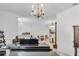 Spacious living room featuring a black grand piano, elegant chandelier, and bright natural light at 6240 Tremayne Dr, Mount Dora, FL 32757