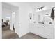 Well-lit bathroom features a white vanity with storage and an adjacent bedroom at 674 Waterman Way, The Villages, FL 32163