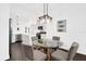 A dining area with dark wood floors, a glass table, and white walls open to the kitchen at 674 Waterman Way, The Villages, FL 32163