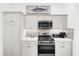 Well-lit kitchen featuring stainless steel appliances, gas range, and white cabinetry at 674 Waterman Way, The Villages, FL 32163