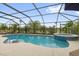 Sparkling screened-in pool with lush landscaping, a spa, and outdoor seating at 674 Waterman Way, The Villages, FL 32163