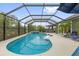 Inviting screened-in pool featuring a spa, lounge chairs, and dining under an umbrella at 674 Waterman Way, The Villages, FL 32163