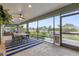 A screened-in porch with a dining table, seating area, ceiling fan, and view of the front yard at 674 Waterman Way, The Villages, FL 32163