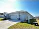 Well-maintained, single-story home featuring a two-car garage and a tidy front lawn at 6853 Se 3Rd Loop, Ocala, FL 34472