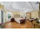 Serene bedroom with tray ceilings, hardwood floors, and an elegant armoire at 686 Aberdeen Run, The Villages, FL 32162