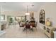 Bright dining area with a round wood table, seating for four, and sliding glass doors at 686 Aberdeen Run, The Villages, FL 32162