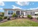 Charming single-story home featuring a manicured lawn, elegant landscaping, and a welcoming entrance with a well-maintained walkway at 686 Aberdeen Run, The Villages, FL 32162