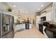 Bright kitchen featuring white cabinets, granite countertops, and stainless steel appliances with a view into the dining and living area at 686 Aberdeen Run, The Villages, FL 32162