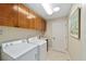 Functional laundry room with cabinets, sink, and modern white washer and dryer at 686 Aberdeen Run, The Villages, FL 32162