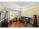 Cozy living room features a gray sofa, hardwood floors, and plenty of natural light at 686 Aberdeen Run, The Villages, FL 32162