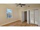 Comfortable bedroom with a closet, wood-look flooring, large window, and a ceiling fan at 709 S Highland St, Mount Dora, FL 32757