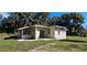 Beautiful home featuring a new roof, large windows, and a sliding glass door to a patio, surrounded by lush greenery at 709 S Highland St, Mount Dora, FL 32757