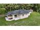Charming home featuring a new roof and landscaping, with large windows and a sliding glass door to a patio at 709 S Highland St, Mount Dora, FL 32757