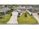 Overhead view of a charming home with a driveway, green lawn, and meticulously arranged landscaping at 853 Abaco Path, The Villages, FL 32163