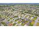 An aerial view of a neighborhood in a suburban community surrounded by tree lined streets at 853 Abaco Path, The Villages, FL 32163