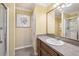 Bathroom featuring a wooden vanity, framed mirror, shower stall, and neutral yellow walls at 853 Abaco Path, The Villages, FL 32163