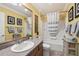 Bathroom with a single vanity, framed art, and a shower-tub combination with a gray and white curtain at 853 Abaco Path, The Villages, FL 32163