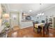 Open concept dining room with wood floors, a modern light fixture, and easy access to the kitchen at 853 Abaco Path, The Villages, FL 32163