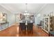 Dining area with hardwood floors, a view to the kitchen, and stylish light fixture at 853 Abaco Path, The Villages, FL 32163