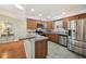 Well-lit kitchen with stainless steel appliances, light countertops and wood cabinets at 853 Abaco Path, The Villages, FL 32163