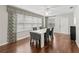 Bright dining room with modern table, wood floor and large windows at 893 Halstead Ter, The Villages, FL 32162