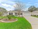 Well-maintained home with a large driveway, lovely landscaping, and a screen front entry at 893 Halstead Ter, The Villages, FL 32162