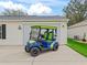 Blue and green Yamaha golf cart is parked in front of the garage with room for storage and easy access at 893 Halstead Ter, The Villages, FL 32162