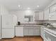 Bright eat-in kitchen with wood floor and white appliances at 893 Halstead Ter, The Villages, FL 32162