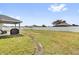 Expansive backyard with a white fence and covered patio area at 9750 Pepper Tree Pl, Wildwood, FL 34785