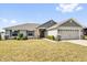 Charming single-story home featuring a well-manicured lawn and a two-car garage at 9750 Pepper Tree Pl, Wildwood, FL 34785