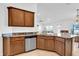 Well-lit kitchen with stainless steel appliances, dark countertops and brown cabinets at 9750 Pepper Tree Pl, Wildwood, FL 34785