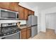 Kitchen featuring stainless steel appliances, dark countertops, and wood cabinets at 9750 Pepper Tree Pl, Wildwood, FL 34785