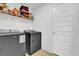 Laundry room with gray washer and dryer, wire shelving, and a white door at 9750 Pepper Tree Pl, Wildwood, FL 34785