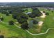 Scenic aerial view of golf course featuring winding paths, lush trees, and tranquil ponds at 9894 Se 138Th Loop, Summerfield, FL 34491