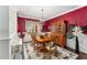 Elegant dining room with red walls, a chandelier, and a large wooden table at 9894 Se 138Th Loop, Summerfield, FL 34491