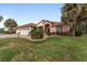 Charming front view featuring a well-kept lawn, lush landscaping, and a welcoming two-car garage at 9894 Se 138Th Loop, Summerfield, FL 34491