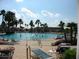 Large community swimming pool with lounge chairs and palm trees on a sunny day at 9894 Se 138Th Loop, Summerfield, FL 34491