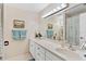 Bathroom vanity with double sinks, large mirror with decorative lighting, and a neutral color palette at 9906 County Road 114A, Wildwood, FL 34785