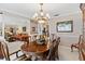 Dining room showcasing classic furnishings, a chandelier, and views into the living room at 9906 County Road 114A, Wildwood, FL 34785