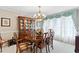 Formal dining room featuring a wood table, chairs, hutch, chandelier, and natural lighting at 9906 County Road 114A, Wildwood, FL 34785