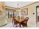 Cozy dining area with a wood table, chairs, chandelier, and a bay window providing natural light at 9906 County Road 114A, Wildwood, FL 34785