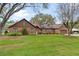 Charming brick home showcasing a well-maintained lawn and mature landscaping at 9906 County Road 114A, Wildwood, FL 34785