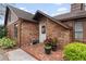 Inviting front entry with decorative brickwork and a charming white door with plants at 9906 County Road 114A, Wildwood, FL 34785