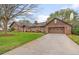 Exterior view of the brick home with a basketball hoop above a two car garage and long driveway at 9906 County Road 114A, Wildwood, FL 34785