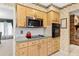 Traditional kitchen featuring light wood cabinets, stainless steel appliances, and decorative wallpaper at 9906 County Road 114A, Wildwood, FL 34785