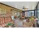 Cozy sunroom with brick walls, wicker furniture, ceiling fan, and a bright atmosphere at 9906 County Road 114A, Wildwood, FL 34785