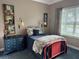 Cozy bedroom with colorful decor, dresser, lamps, and large window, creating a warm and inviting space at 10267 Julia Isles Ave, Oxford, FL 34484