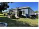 Back exterior view of the house with a screened in patio and landscaped yard at 10267 Julia Isles Ave, Oxford, FL 34484